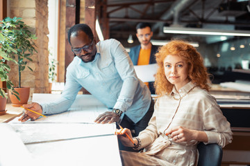 Wall Mural - Blue-eyed appealing interior designer sitting near boss