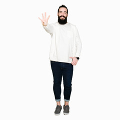 Wall Mural - Young man with long hair and beard wearing sporty sweatshirt showing and pointing up with fingers number four while smiling confident and happy.