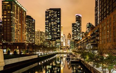 Chicago city illuminated buildings in the evening. Reflections on the river canal