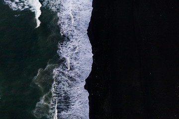 Overhead view of scenic sea waves on black sand beach in Iceland