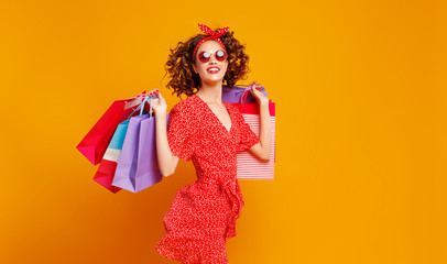 Wall Mural - concept of shopping purchases and sales of happy   girl with packages  on yellow background.