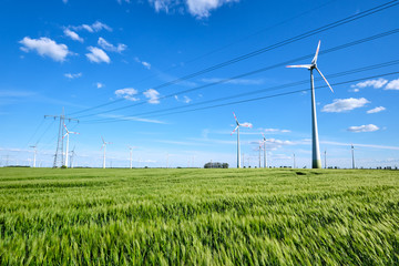 Power lines and wind engines on a sunny day seen in Germany