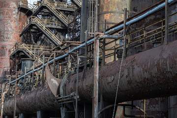 Wall Mural - Complex background of rusty metal pipes, walkways, urban industrial architecture, horizontal aspect