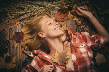 Wall Mural - Sensual woman wearing pullover and looking at camera. Attractive young woman wearing in fashionable seasonal clothes having Autumnal mood. Girl in autumn in a seasonal clothes whith golden leaf.