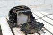 © Andrii - Burning toaster. Toaster with two slices of toast caught on fire over white background
