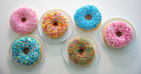 Wall Mural - Doughnuts with colorful decoration on white color background. Top view