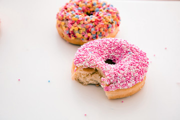 Doughnuts pink and pastel on white color background.