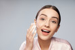 © Yakobchuk Olena - Cheerful young woman washing face with foaming cleanser