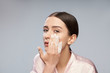 © Yakobchuk Olena - Beautiful young woman washing face with foaming cleanser