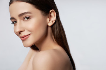 happy young woman with natural makeup posing in studio