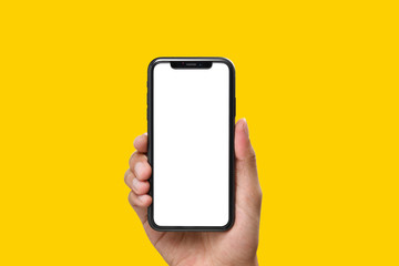 hand holding the black smartphone with blank screen and modern frame less design on yellow colour ba