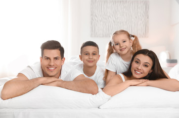 Canvas Print - Portrait of happy family on large bed in room