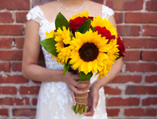 Bride With Bridal Bouquet Of Sunflowers And Red Roses, Focus On Flowers.