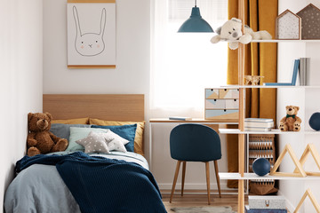 Workspace with desk and chair in elegant teenager's room with blue and orange design