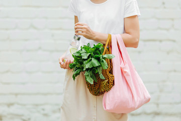 Wall Mural - Female hands hold eco bag of vegetables, greens and reusable water bottle. Zero waste. Sustainable lifestyle concept.