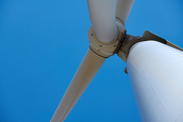 Electricity wind generator on bright cloudy sky background - wind energy and technology concept