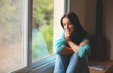 Wall Mural - woman sitting on the window sill