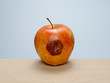 © Mstock - Rotten to the core, bruised apple on wood table