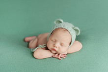 Sleeping Newborn Baby On A Green Background. Photoshoot For The Newborn. A Few Days From Birth.