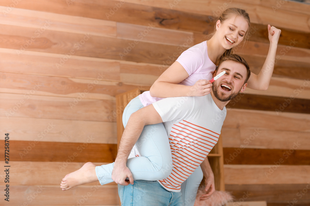 Happy couple with pregnancy test at home