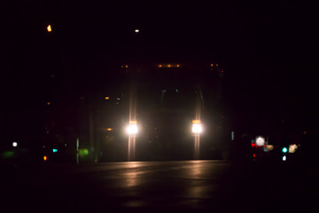 Ambulance headlights on road at night on dark road