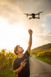 © lightpoet - Young man flying a drone in warm evening sunlight