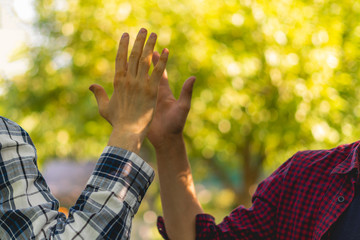 two friends beat high five outdoors on a summer day, friendship success relationship