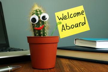 Welcome aboard concept. Funny cactus on workplace in the office.