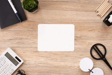 Poster - top view blank white paper note with office stationery on wooden table with copy space.student stuff on desk.education concept.