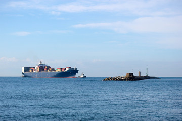 Large container ship with a tugboat near the Livorno port, Italy