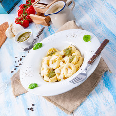 Tortellini di formaggio with basil pesto and cheese sauce