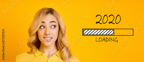 Leinwand Poster  Blonde biting her lip and looking at 2020 loading process