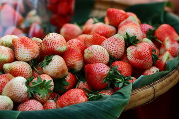 fresh red strawberries in a bamboo basket.