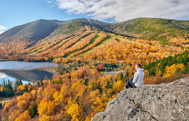 Wall Mural - Woman hiking at Artist's Bluff in autumn. View of Echo Lake. Fall colours in Franconia Notch State Park. White Mountain National Forest, New Hampshire, USA