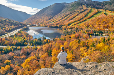 Wall Mural - Woman hiking at Artist's Bluff in autumn. View of Echo Lake. Fall colours in Franconia Notch State Park. White Mountain National Forest, New Hampshire, USA