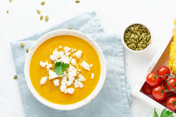 Wall Mural - Pumpkin cream soup with feta cheese, autumn homemade food, white background, top view