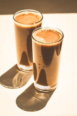 Iced coffee with milk cocktail on white table.