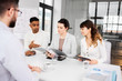 © Syda Productions - new job, hiring and employment concept - international team of recruiters with tablet computer and folder having interview with male employee at office