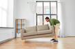 © Syda Productions - accommodation, furniture and interior concept - happy indian man moving sofa at home