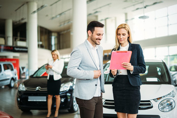 Young woman consultant in show room talking with client