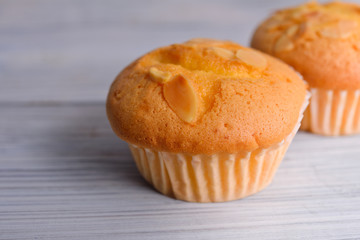 muffin cup cake with almond sliced in paper cup on wooden background