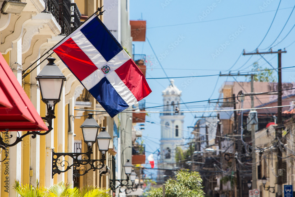 Arzobispo Merino street. Santo domingo. Flag of the Dominican Republic on the wall of a building in the colonial zone - obrazy, fototapety, plakaty 