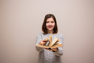 Wall Mural - Portrait of young brunette woman with book in her hand