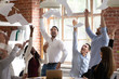 Euphoric diverse business team tossing throwing papers celebrate success victory