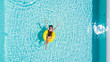 © F8  \ Suport Ukraine - Vacation concept. Top view of slim young woman in bikini on the yellow air inflatable ring in the swimming pool.