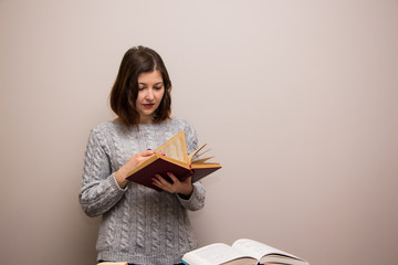 Wall Mural - Portrait of young brunette woman with book in her hand