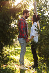 Poster - Image of happy couple man and woman laughing while looking at each other in green park