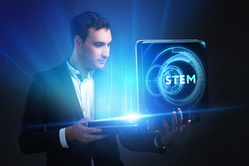 The concept of business, technology, the Internet and the network. A young entrepreneur working on a virtual screen of the future and sees the inscription: STEM