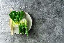 Baby Bok Choi Halves On A Plate Gray Background. Top View, Horizontal Orientation With Copy Space