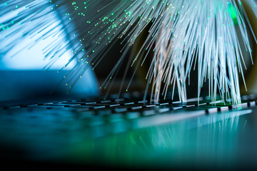 Wall Mural - Glowing colorful optical fibres over laptop computer keyboard , image for background.